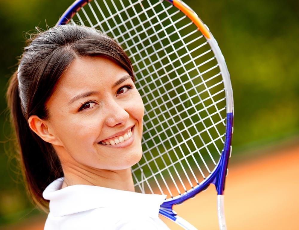 Smiling woman holding a tennis racket